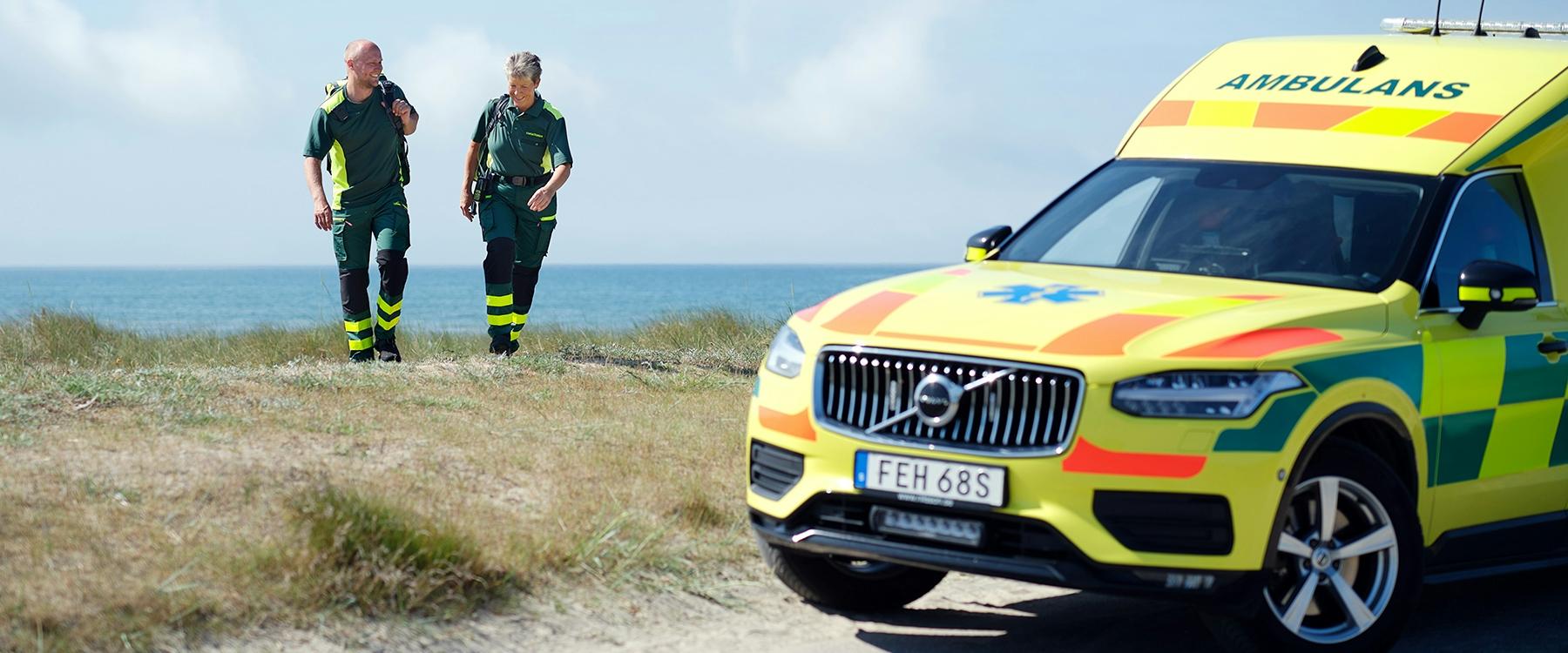 Ambulanspersonal vid ambulans på strand
