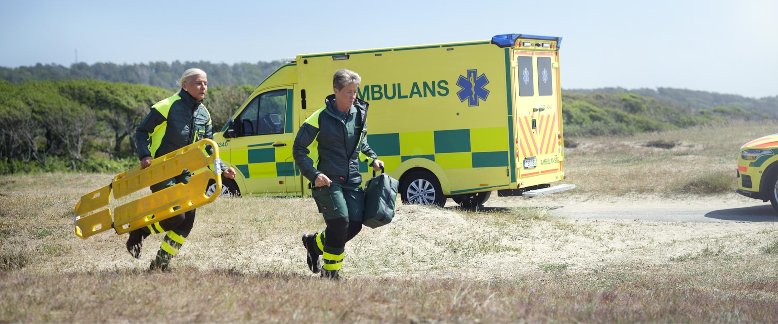 Springande ambulanspersonal i arbetskläder