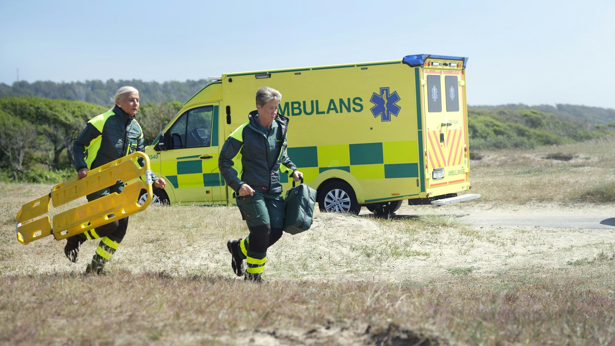 Springande ambulanspersonal i arbetskläder