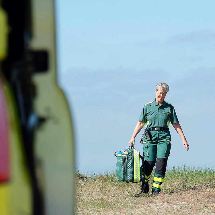 Ambulanspersonal i gröna arbetskläder utomhus